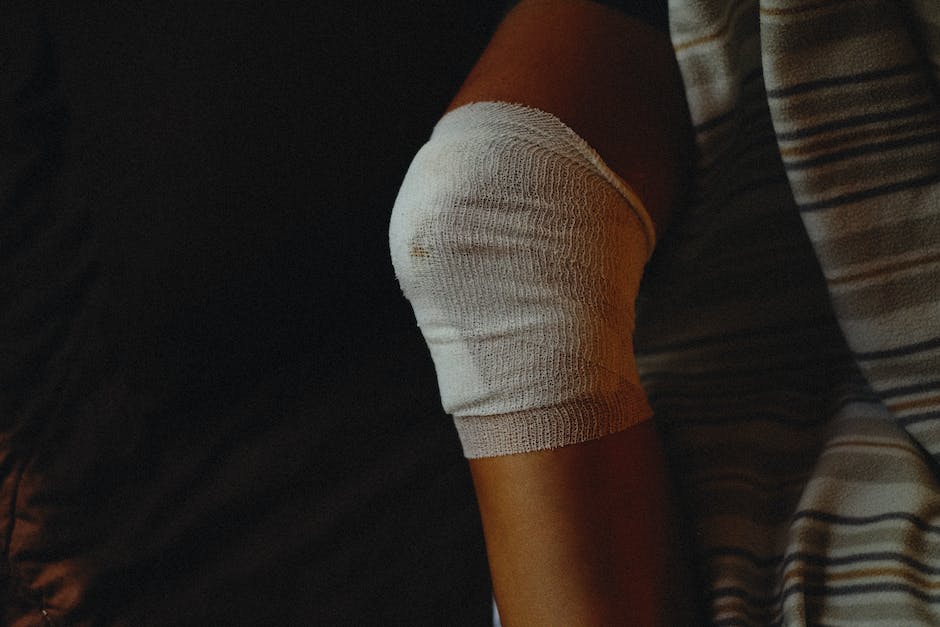 Image description: A person holding an ice pack on their injured knee, representing sports injury recovery.
